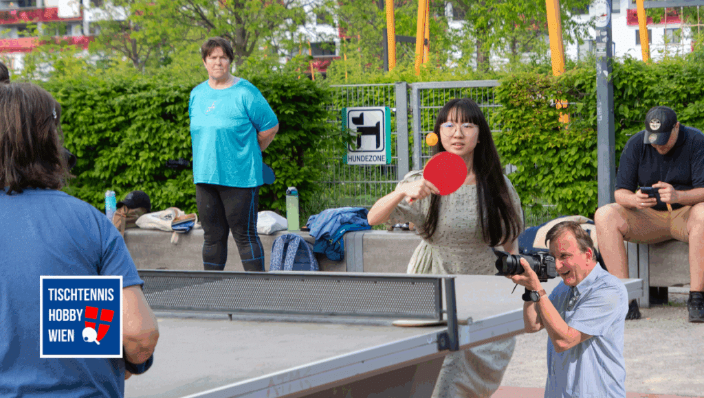 Teilnehmerinnen und Teilnehmer spielen gemeinsam Tischtennis im Rudolf-Bednar-Park beim World Table Tennis Day 2025 in Wien - ein Fest der Inklusion und Begegnung.